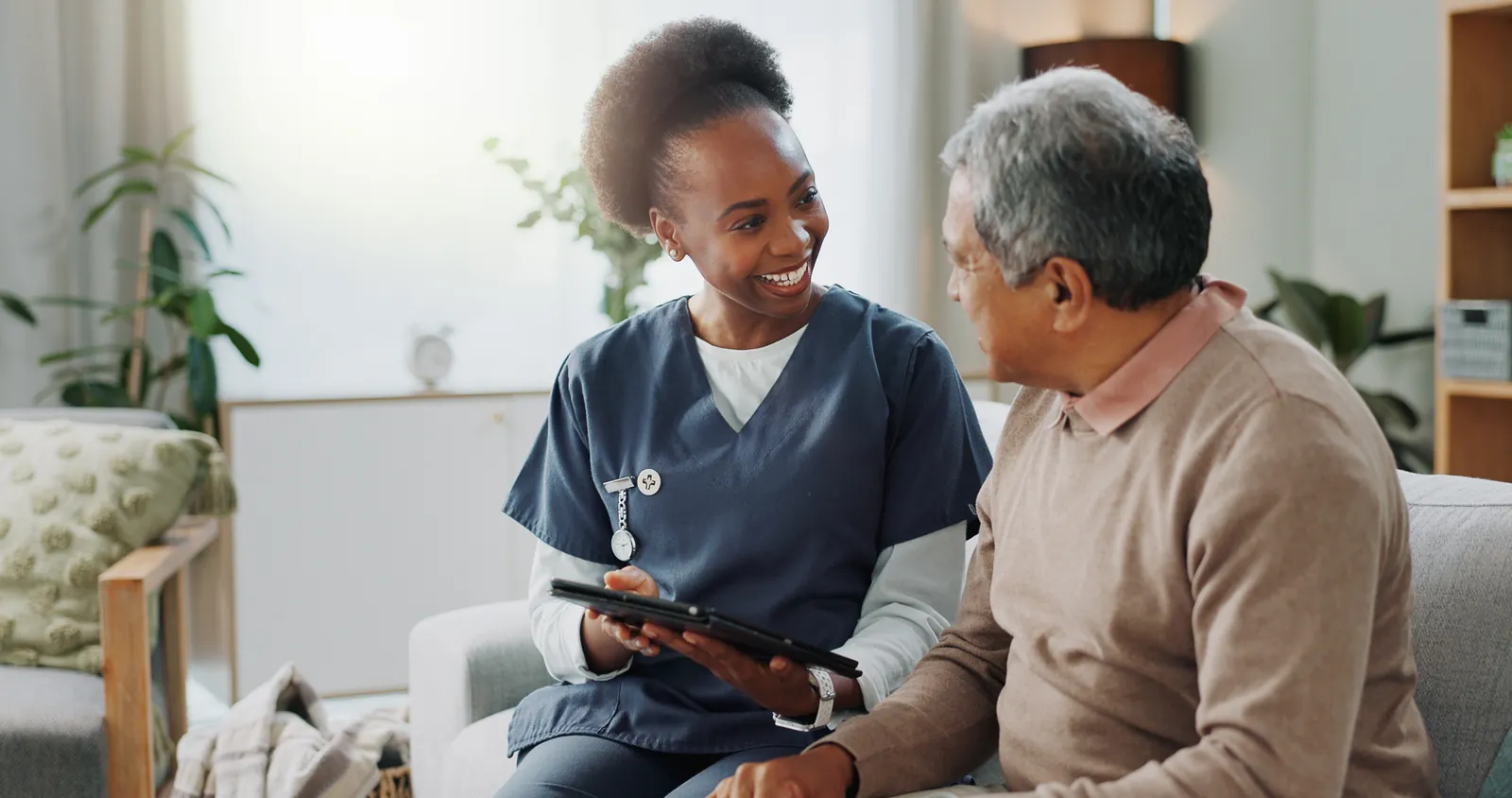 Nurse and older man reviewing notes together on a tablet